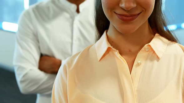 Business colleagues standing together with arms crossed in office