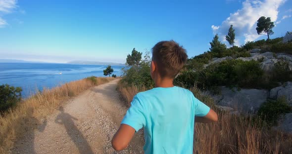 Boy in Blue t-Shirt During Running in Park by Beach in Sunny Summer Morning.