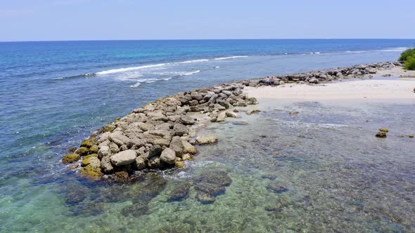 Aerial view of rocky shore and tropical sandy beach during sunny day on Dominican Republic