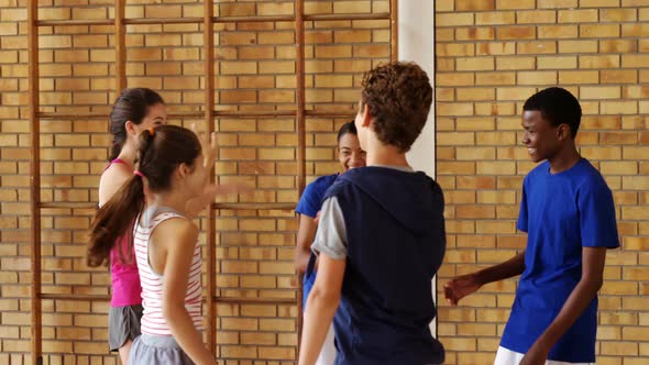 Group of happy high school kids giving high five to each other