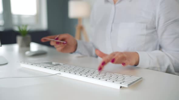 Woman Typing Credit Card Number on Computer Keyboard