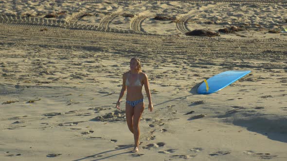 A young woman surfing in a bikini on a longboard surfboard.