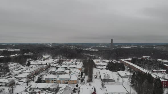 Nordic Town Covered in Snow In Winter Forest Landscape Aerial Rising