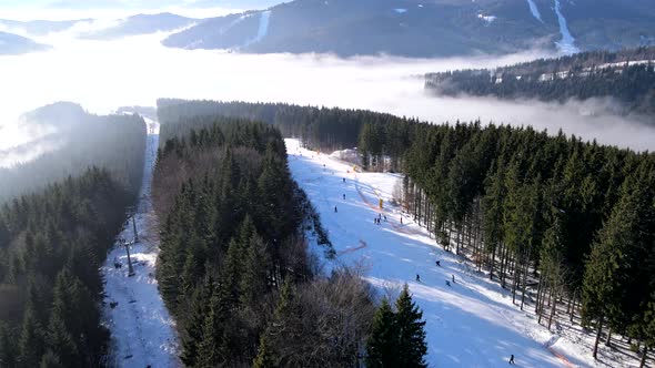 Aerial View of the Ski Resort in Mountains Covered with Pine Trees Forest