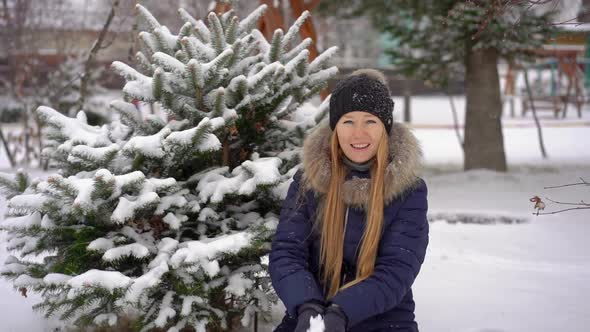 A Young Woman in a Park Throws Snow u Into the Air. Slowmotion Shot