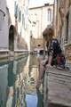 Caucasian redhead woman with floral dress sitting near a canal in Venice barefoot - PhotoDune Item for Sale