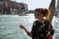 Caucasian redhead woman with floral dress looking at grand canal Venice - PhotoDune Item for Sale