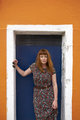 Caucasian redhead woman with floral dress and colorful building - PhotoDune Item for Sale