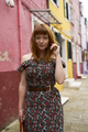 Caucasian redhead woman with floral dress and colorful building - PhotoDune Item for Sale