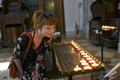 Caucasian redhead woman with floral dress looking at candles in a church in Venice - PhotoDune Item for Sale