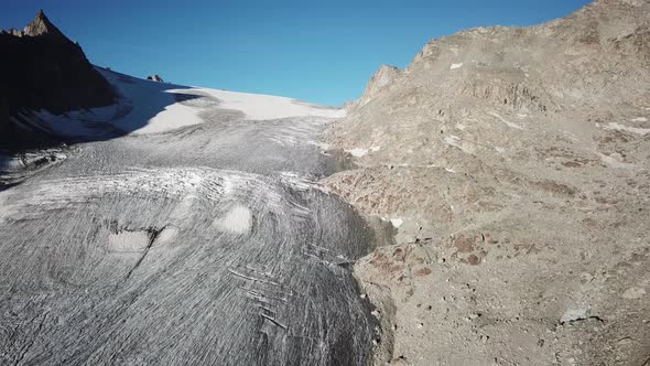 drone aerial view of a glacier in the high rocky mountains of Switzerland, alps