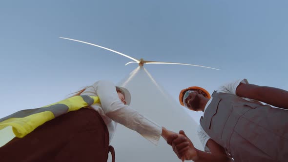 Teamwork of Windmill Engineer Group Worker Working Shaking Hands on Site at Wind