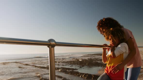 Mother and son pointing away the sea