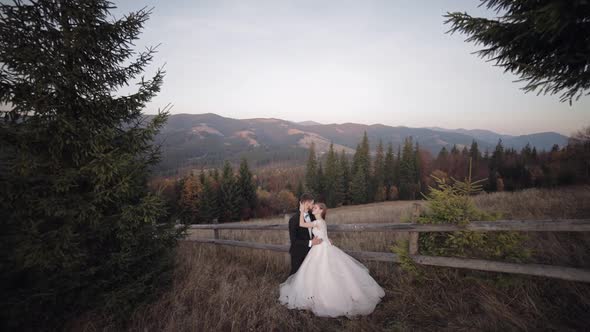 Newlyweds. Caucasian Groom with Bride on Mountain Slope. Wedding Couple. Happy