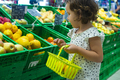 Little girl buying lemons in supermarket. Child hold small baske - PhotoDune Item for Sale