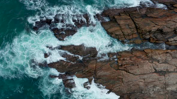 Ocean Waves Crash Against Stony Rocks During Sunset on the Island of Sri Lanka. Aerial View