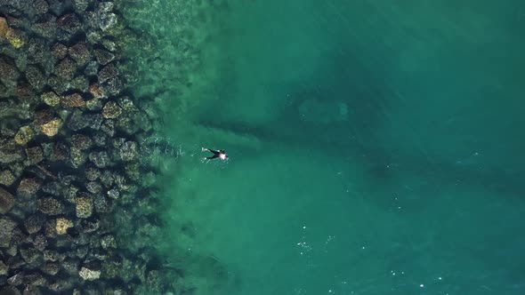 One person snorkeling above a sunken city infrastructure treated sewer pipe outlet in a popular wate