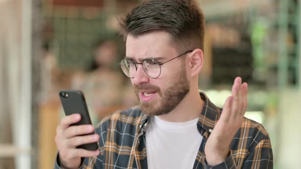 Portrait of Upset Young Man Having Loss on Smartphone 