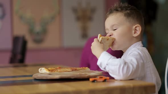 Little boy eats delicious pizza. Italian pizza