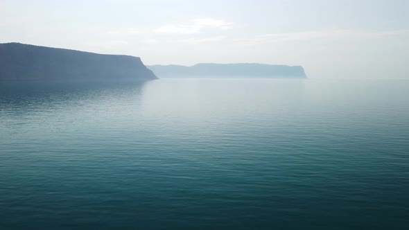 Aerial View From Above on Calm Azure Sea and Volcanic Rocky Shores