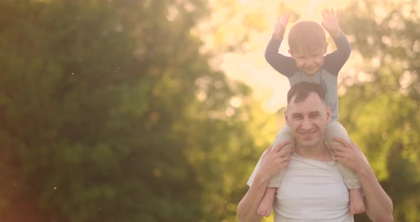 Loving Young Father and Son Play on the Grass in the Summer at Sunset in Slow Motion