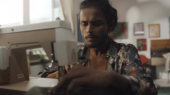 Indian Dressmaker Using Sewing Machine in Workshop