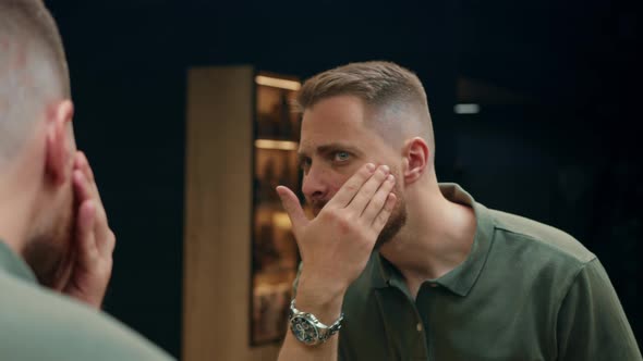 Barbershop: a male client examines his new haircut