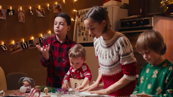 Cute Children Making Cookies with Mother on Christmas Day at Home