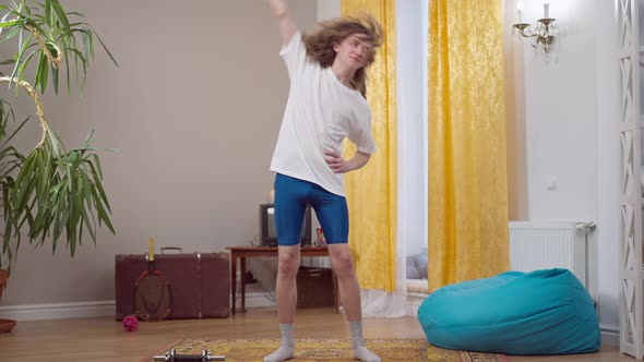 Wide Shot Portrait of Skinny Young Retro Man Exercising Indoors in 1980s or 1990s