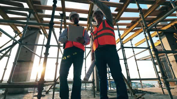 Engineers Work Together on a Building Site alt
