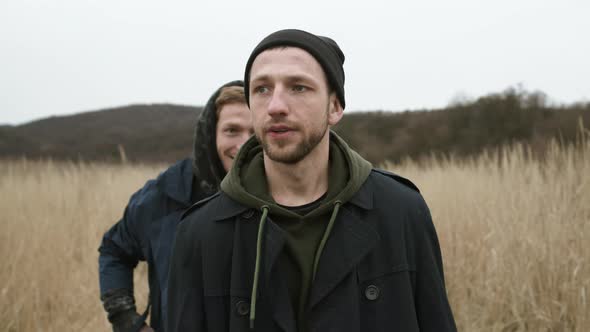 Two Friends Walking On The Road In The Field.