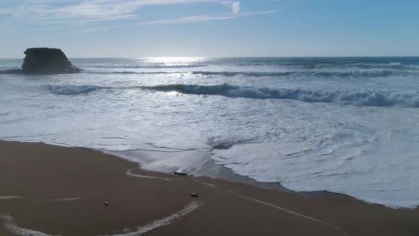 Medium waves crashing by beachfront