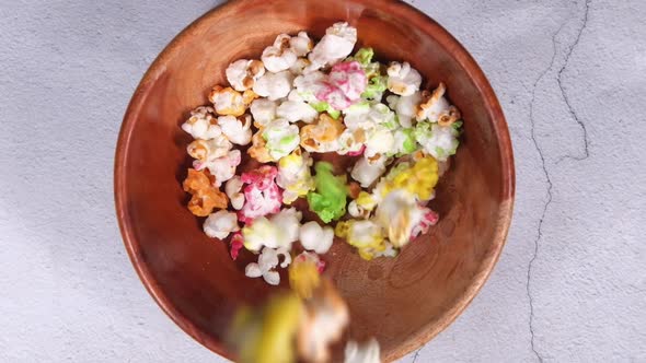 Dropping Popcorn in a Bowl on Wooden Desk