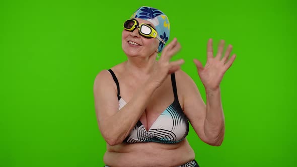 Senior Pensioner Woman Tourist in Swimsuit Bra Swim Goggles and Hat Dancing Celebrating Smiling