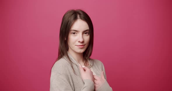 Beauty Attractive Woman with Beautiful Eyes Arranges Hair on Pink Background