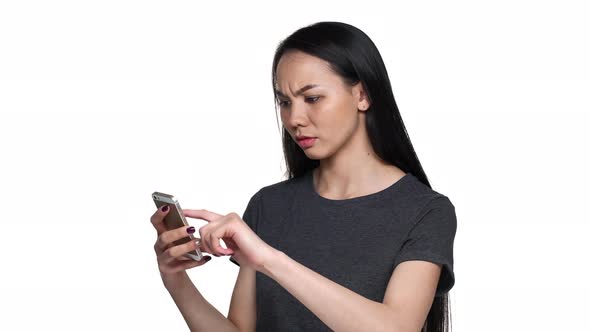 Portrait of Asian Woman 20s Wearing Casual Clothes Holding Smartphone and Browsing Internet to Find