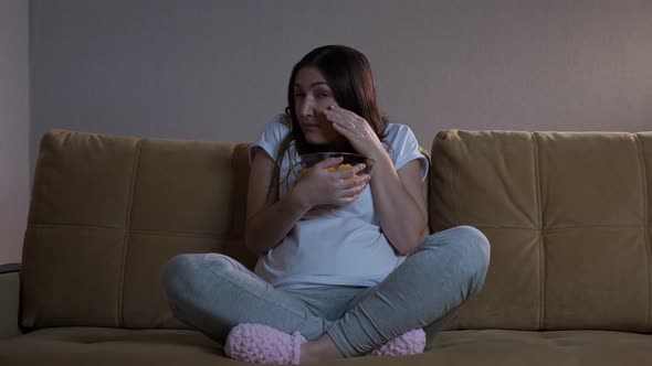 Brunette Lady Eats Chips and Gets Scared Watching Movie