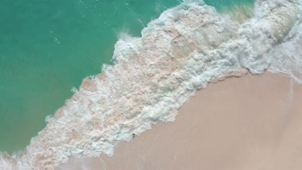 Slow Motion Top View of Sea Foamy Splashing Waves on a White Sand Beach