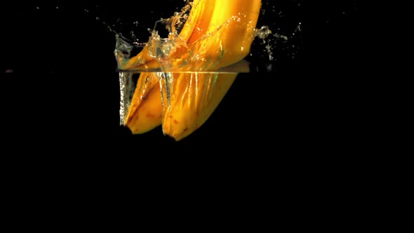 Super Slow Motion Fresh Bananas Fall Into the Water with Splashes