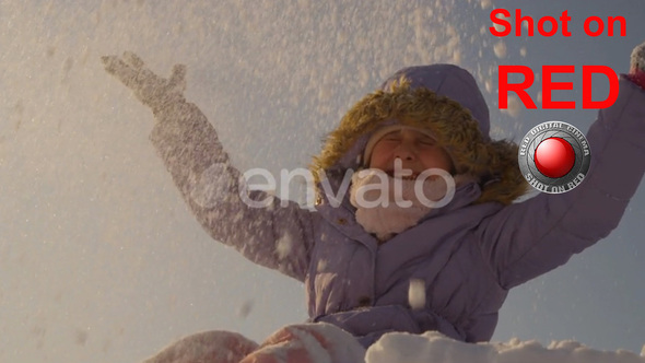 Playing with Snow Portrait of Happy Child Sitting and Throwing Snow in Air slow motion shot on RED