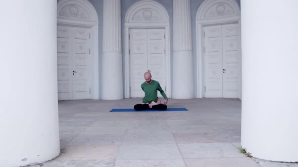 a Man Does Yoga Indoors with Many Doors Doing an Asana Exercise Padmasana