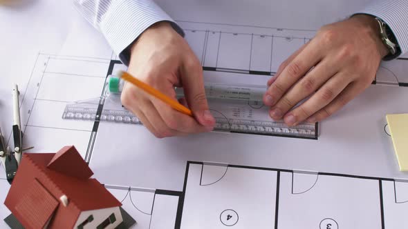 Architect Hands with Ruler Measuring Blueprint