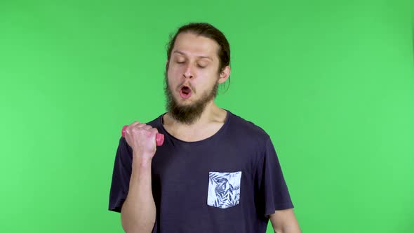 A Man is Exercising with Small Pink Dumbbells