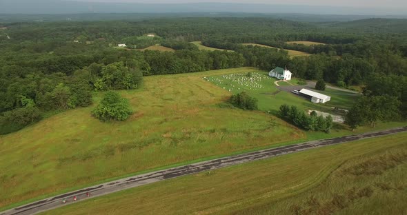 Aerial views of family bicycling along pastoral country roads.