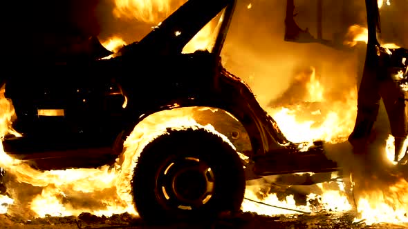 Burning car body, burning iron, broken car on fire