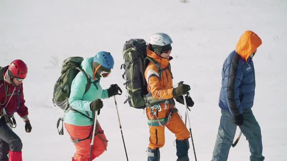 Group of Tourists Follows Each Other Along the Path on Snowshoes and in Equipment