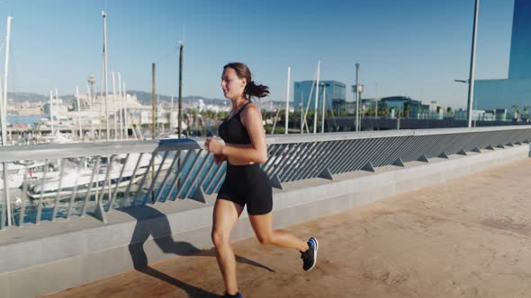 Sportswoman Jogging Near Port in Morning