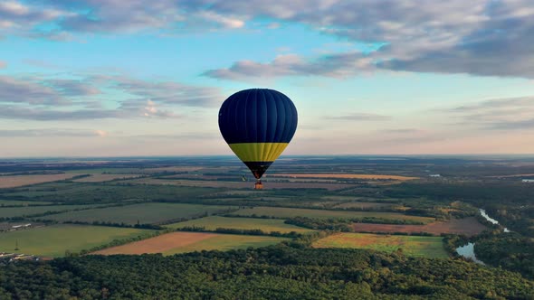 Multicolored balloons fly over trees. Nice top view of the park, forest covered with greenery.