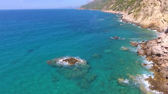 Aerial Clear Reef and Rocky Untouched Coastline of Bright Turquoise Sea