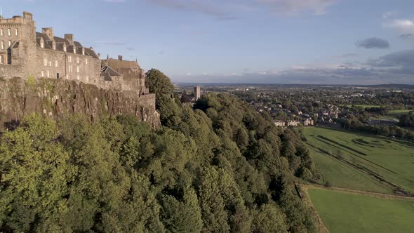 Aerial shot flying easterly along Stirling castle battlements on a clear and sunny day, revealing th